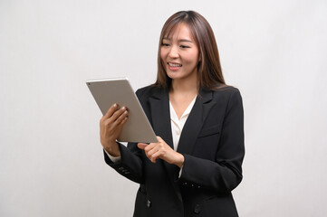 Fototapeta premium Young asian businesswoman using tablet over white background, technology concept