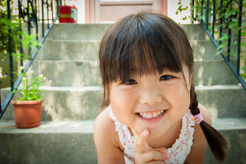 Young asian girl with long black hair smiling at the camera