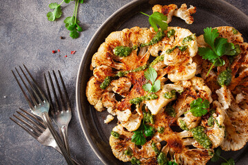 cauliflower steaks with herb sauce and spice. plant based meat substitute