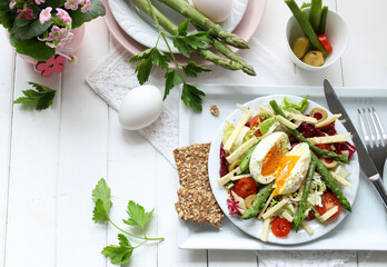 Insalata di primavera con asparagi e uovo in camicia su sfondo bianco. Concetto di cibo sano. Direttamente sopra.