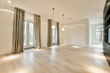 an empty living room with wood flooring and large sliding glass doors leading to the patio area in the house