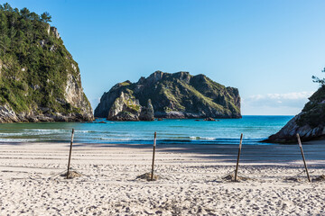 Beach with mountains and umbrella stands