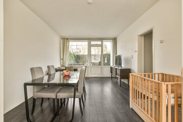 a dining room with wood flooring and white walls there is an open door leading to the outside patio area