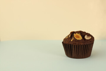 fragrant homemade
chocolate cupcake with walnuts on a light background. for banners, postcards, napkins, flyers, business cards, screensavers, labels, etc.