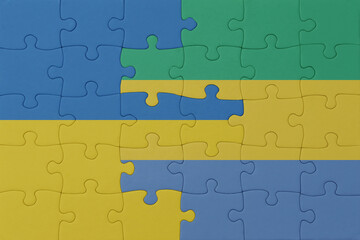 puzzle with the national flag of ukraine and gabon . macro.concept.