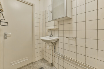 a small bathroom with white tiles on the walls and floor, including a sink in the wall is made out of tile