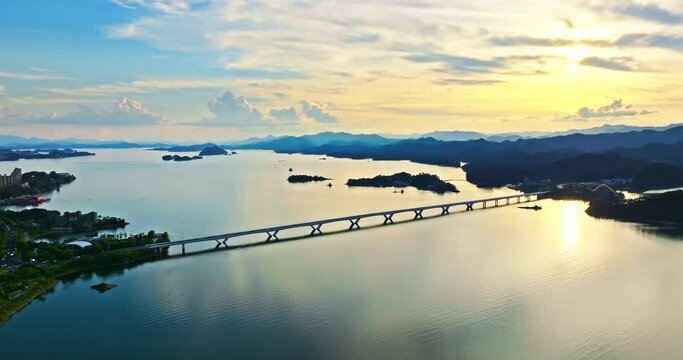 Aerial footage of beautiful Qiandao Lake natural landscape in Chun'an, Hangzhou, Zhejiang Province, China. lake and bridge with mountain natural scenery at sunset.