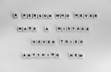 Deep life quote about mistakes written with letter beads on a white surface