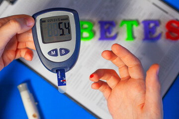 The guy measures the level of sugar in the blood with a glucometer in diabetes. Close-up, selective focus.