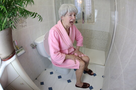 Senior woman feeling constipated in the bathroom 