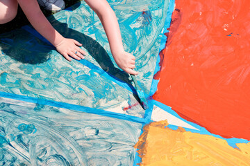 New Jersey, USA - April 21, 2023: Joyful Child Creatively Painting a Colorful Mural..