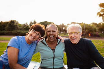 Happy multiracial senior friends having fun smiling at the camera after training activities in the park