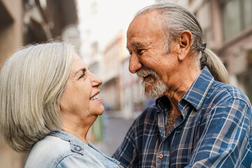 Happy senior couple having tender moments in the city - Elderly people and love relationship concept - Powered by Adobe