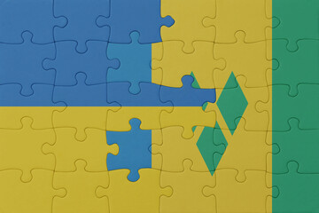 puzzle with the national flag of ukraine and saint vincent and the grenadines . macro.concept.