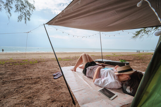 asian woman camping and relax on beach with sea background on summer vacation