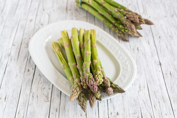 Grüner Spargel ganze Stangen auf einer Servierplatte 