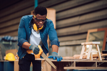 African american carpenter man working in wood factory, small business wood workshop. Timber...
