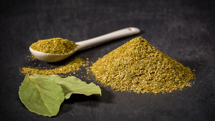 Aromatic spices bay leaf. Spoon and pile of ground dried, fresh laurel spice. Recipe ingredients.