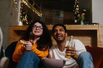 A company of friends in the evening in a cafe spend time together watching their favorite TV series.