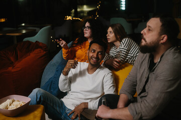 Cheerful young people watching a movie in a cafe.