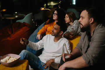 Cheerful young people watching a movie in a cafe.