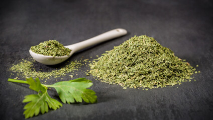Spices for recipes. Parsley. A spoon and a pile of ground dried parsley spice. Recipe ingredients.