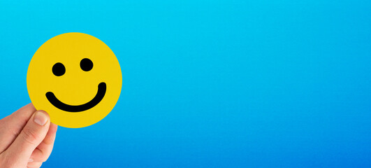 Happy smiley face emoticon with copy space on blue background