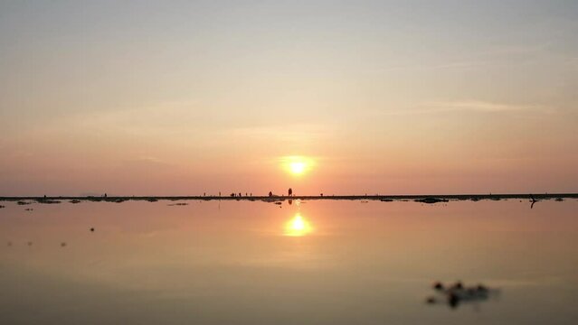 Time lapse of silhouette people moving on the beach of Ko Pha Ngan Island in Thailand at sunset