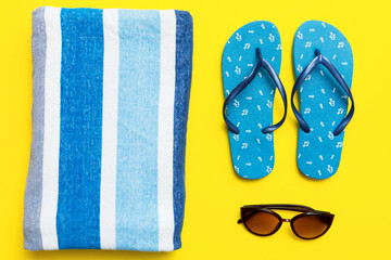 Summer travel concept. Flip flops, sunglasses and starfish on white. Top view on colored background