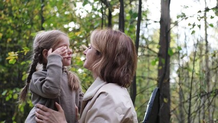Hello September. A young mother and little daughter walk in the city park in autumn.