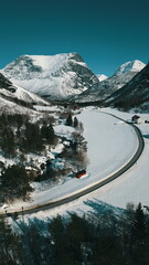 Aerial view of the road in the mountains. Beautiful winter landscape. Vertical frame.
