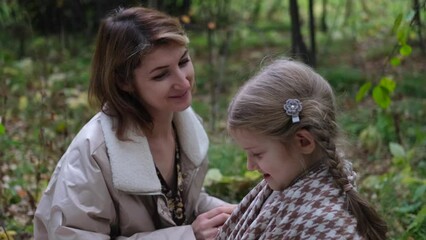 Hello September. A young mother and little daughter walk in the city park in autumn.