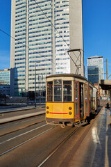 vintage tram in the city at early morning with glass skyscrapers in background in business district...