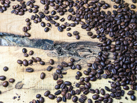 Coffee beans on wooden background. Close-up image. © Sergio