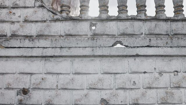 Damaged surface, concrete fence, Shot holes. War in Ukraine, concrete fence with bullet holes or after shelling has been demolished