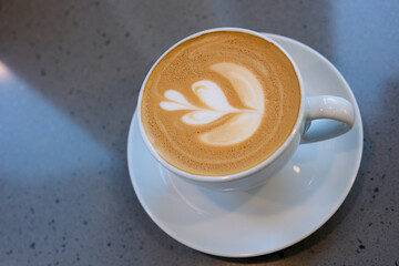 a cup of capuccino coffee flower pattern from above. High quality photo