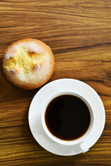 Pan dulce y taza de café sobre una mesa de madera, vista superior. Llamado pan de yemas.