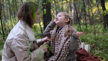 Hello September. A young mother and little daughter walk in the city park in autumn.