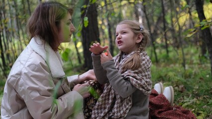 Hello September. A young mother and little daughter walk in the city park in autumn.
