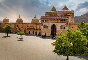 Fototapeta premium Amber Fort illuminated by warm light of the rising sun and reflected in the lake. Famous Rajasthan landmark