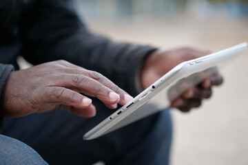 African american man uses tablet computer. Black man hands holds tablet pc