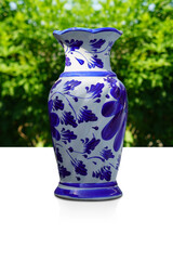 antique blue and white ceramic vase on white floor, blur green trees background, object, decor, vintage, fashion, nature, copy space