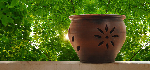 antique brown clay pot on put on the cement wall, green trees background, object, decor, modern, gift, copy space