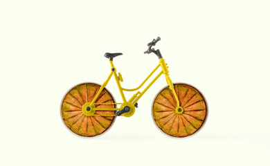 Bicycle with wheels made with round baking trays with baklavas cut into slices. Isolated pastel...