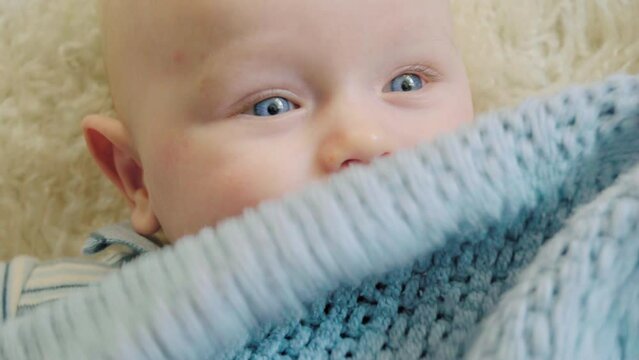 Adorable baby boy with blue eyes smiling and giggling in the room