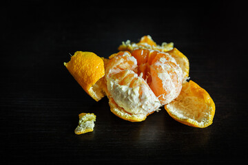 Peeled orange on a black table and background