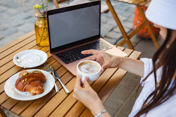 Freelance writer enjoys coffee outside with laptop.