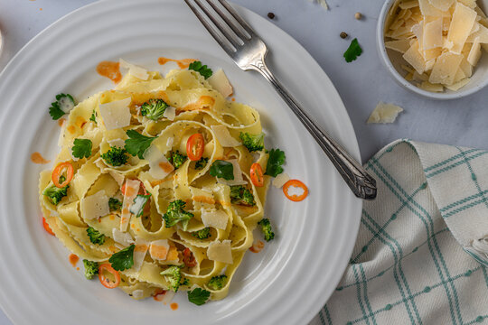 Italian pasta noodles primavera. Bowl of shaved parmezan cheese.