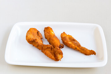 Fried Chicken breast hot crispy strips crunchy chicken tenders  isolated on white background.Nuggets isolated on white background on a plate
