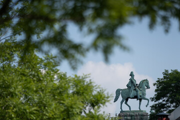 Das Kaiser-Wilhelm Denkmal in Köln umrahmt von Baumgrün.